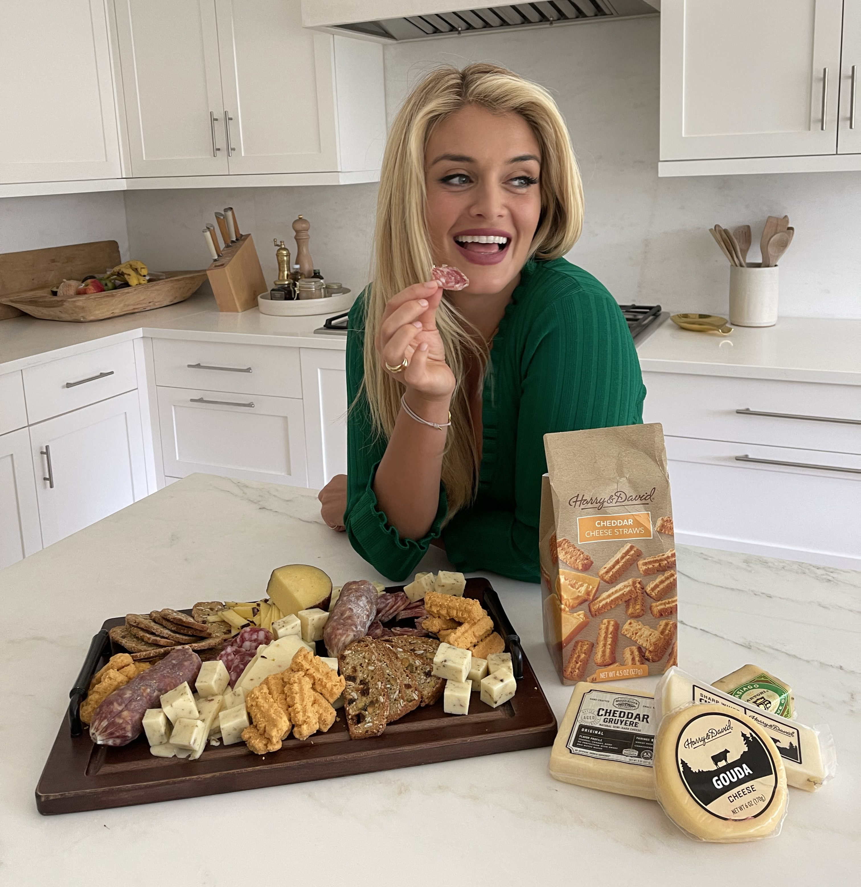 Chef Daphne Oz eating from a charcuterie board that has meats and cheese from Harry and David 