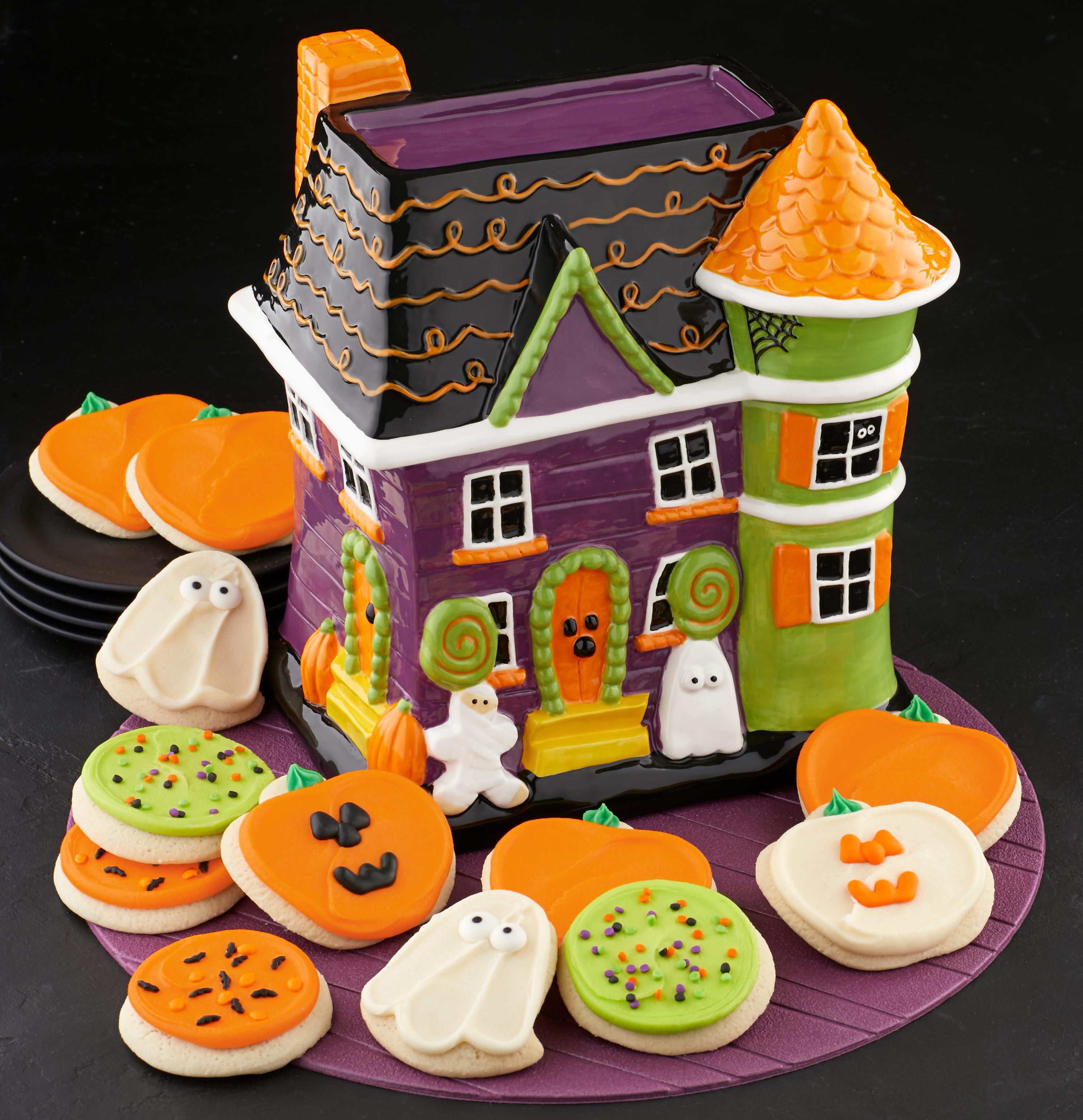 A Cheryl’s Cookies Collector’s Edition Halloween Fun House Cookie Jar with buttercream frosted cookies shaped as pumpkins and ghosts