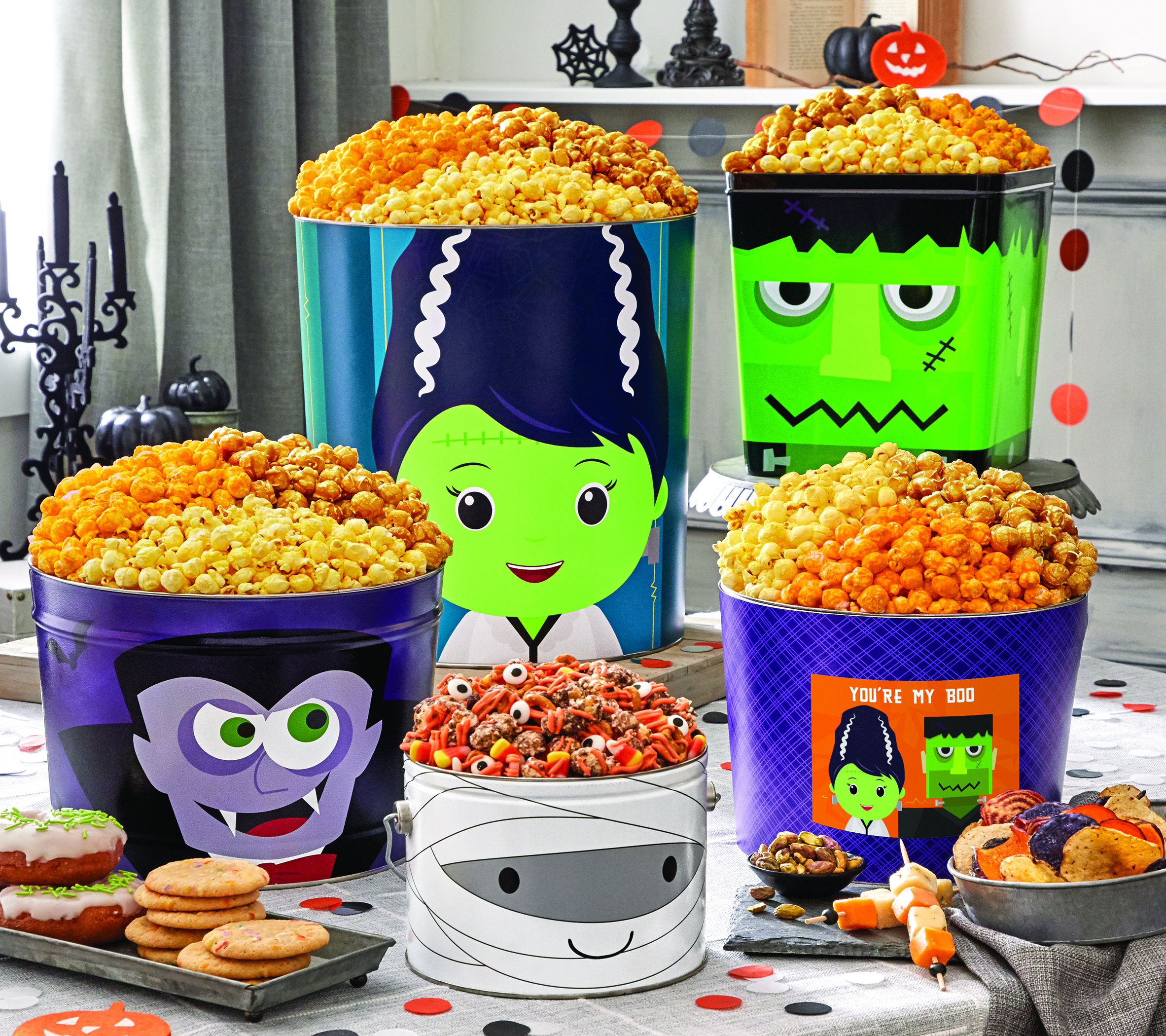 An assortment of The Popcorn Factory Monster Mash Popcorn Buckets on a black, white, and orange decorated table
