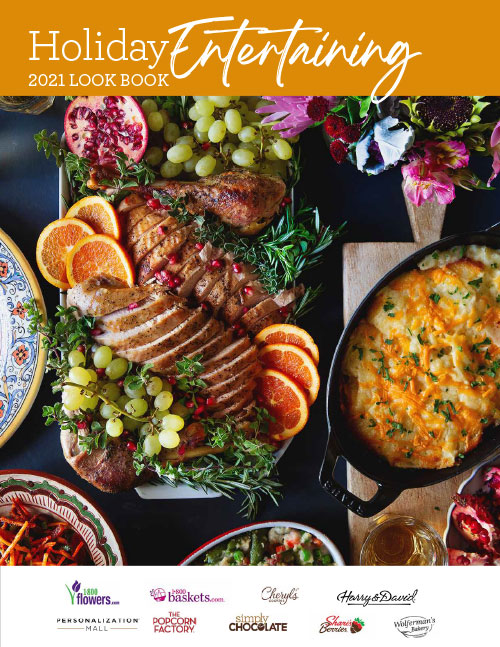 A table set with multiple dishes of gourmet food and festive decor from the cover of the 2022 Holiday Entertaining Look Book