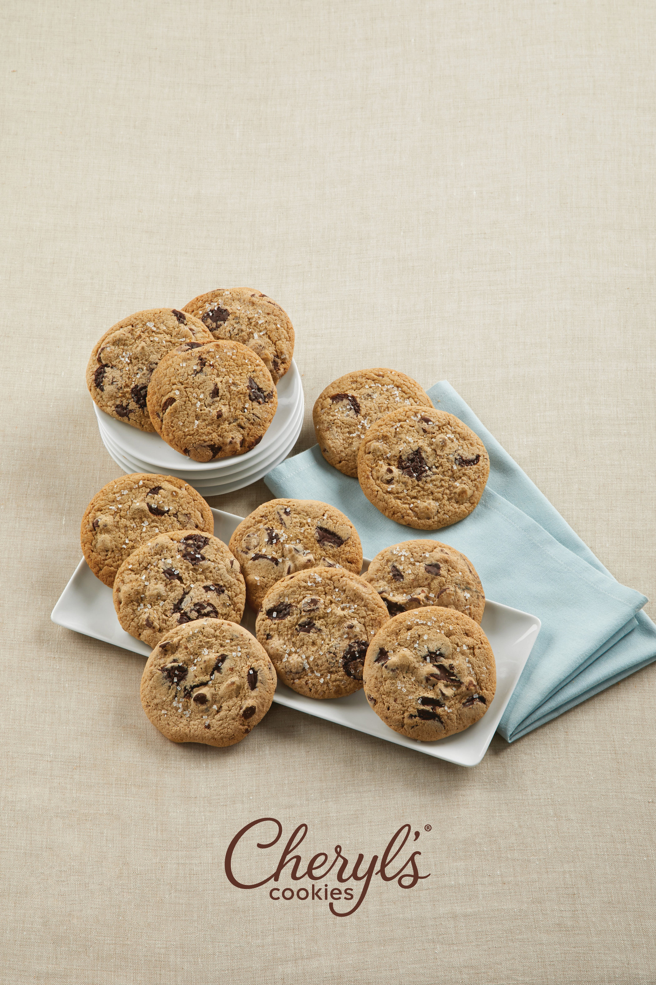 A display of chocolate chip and sea salt cookies from Cheryl's Cookies on white plates and a light blue napkin