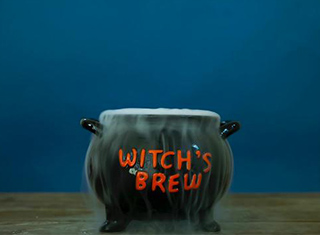A black cauldron from the Cheryl’s Cookies Halloween Witch’s Brew set on a wooden table