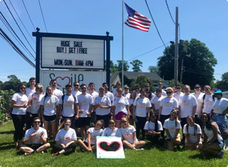 A group of interns posing together during a Summer of a Million Smiles volunteer event at Smile Farms, the signature philanthropic partner of 1-800-Flowers.com Inc. 