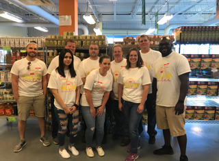 A group of employees pose after volunteering as part of the 1-800-Flowers.com Inc Summer of a Million Smiles program