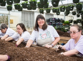 A group of farmers from Smile Farms planting together at a soil table
