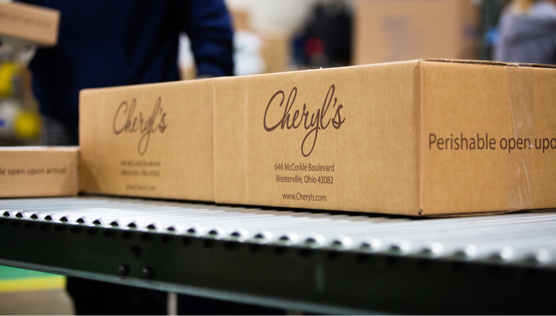 Two boxes of Cheryl's Cookies on a conveyor belt